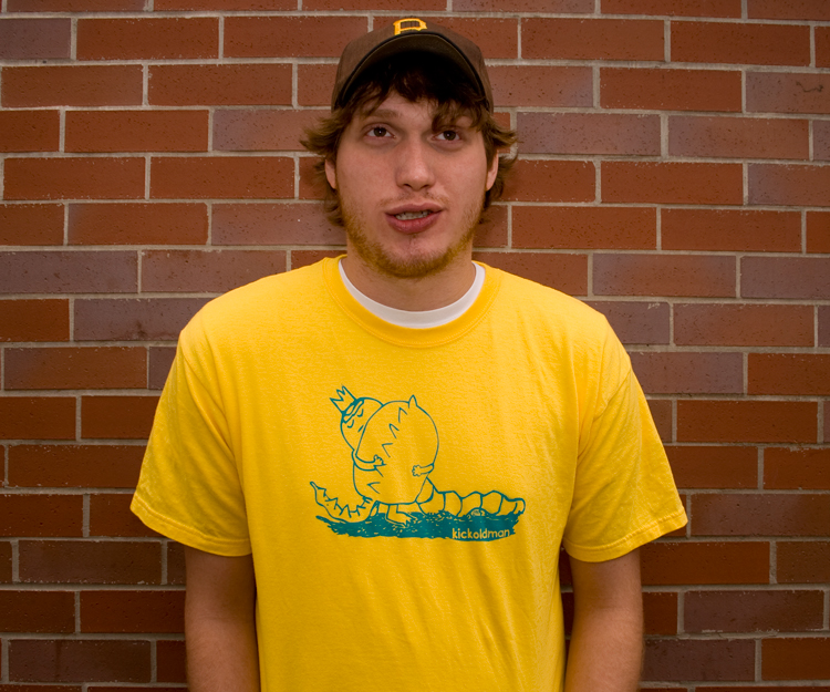 Courtney Robinson with yellow shirt in front of brick wall